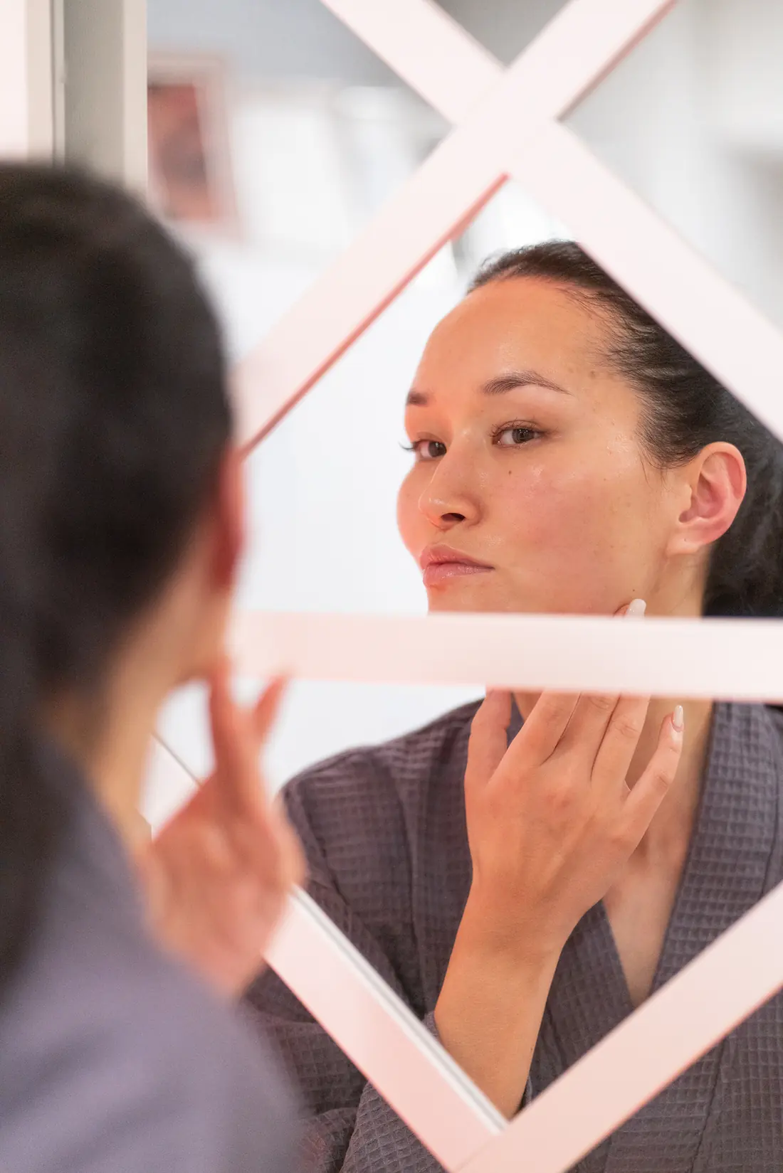 Client checking her camera-ready glow in the mirror after an Oxygen Facial at SI Glam Glow