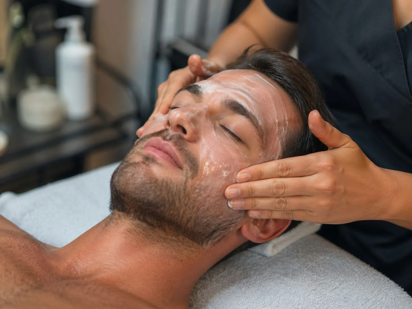 Licensed esthetician cleansing a client's skin during a Gentleman's Facial at SI Glam Glow in Staten Island