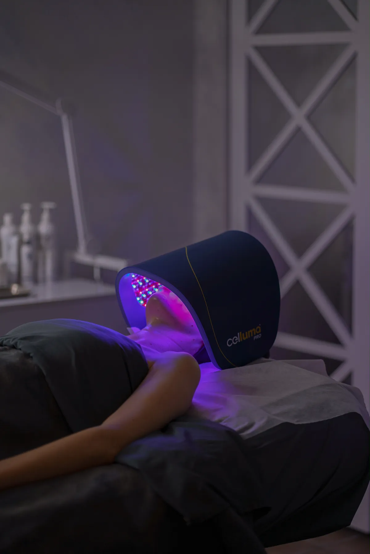 Client relaxing under LED light therapy at SI Glam Glow